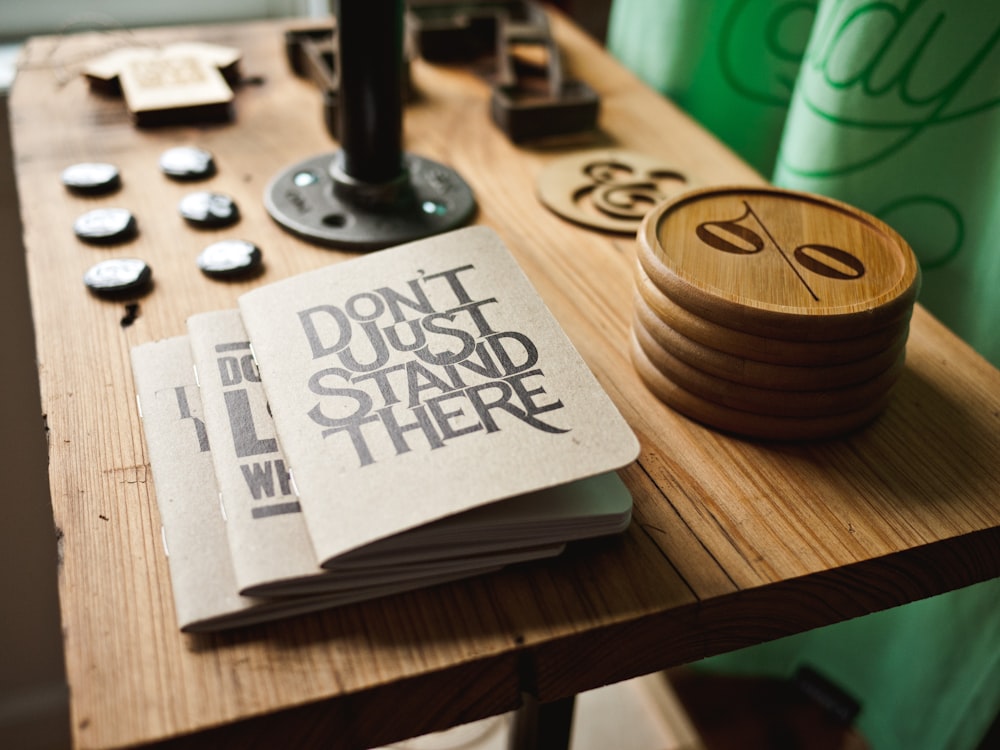 three gray papers near round brown wooden boards on table