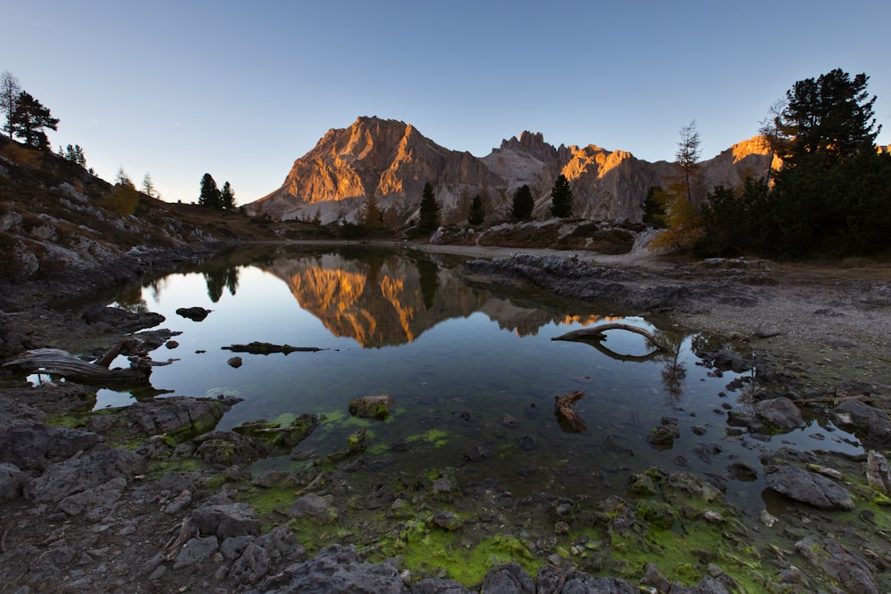 specchio d'acqua riflesso della montagna durante l'ora d'oro