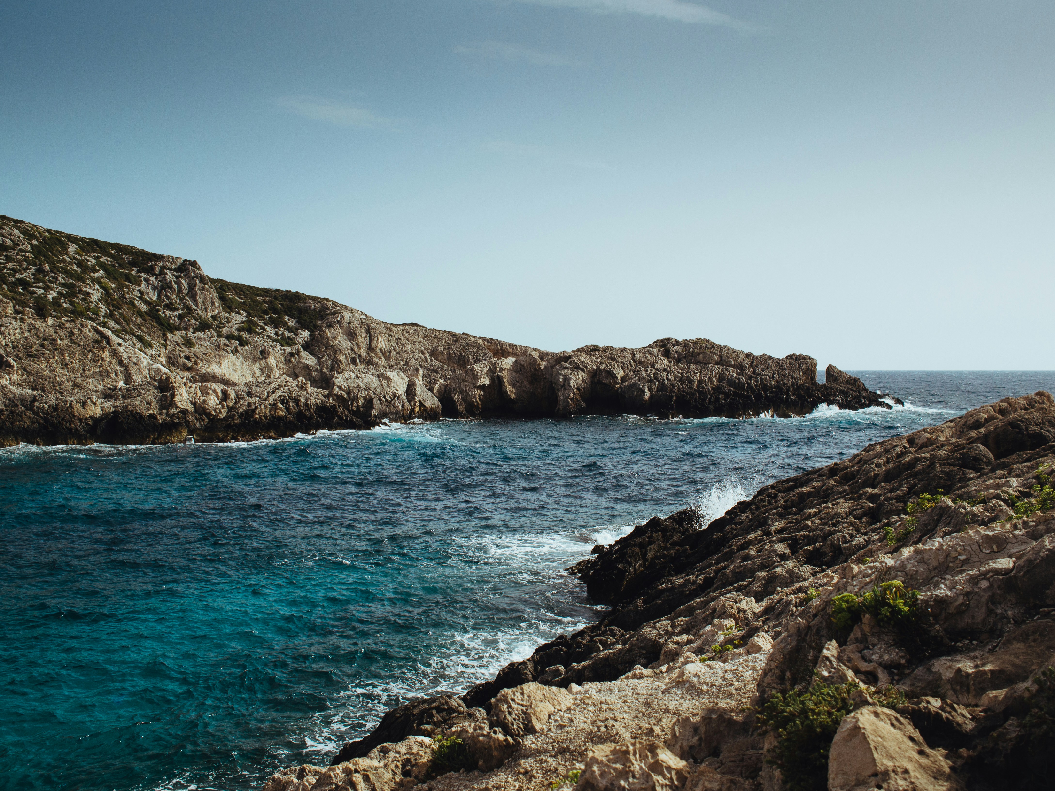 brown rock formation near sea mediterranean teams background