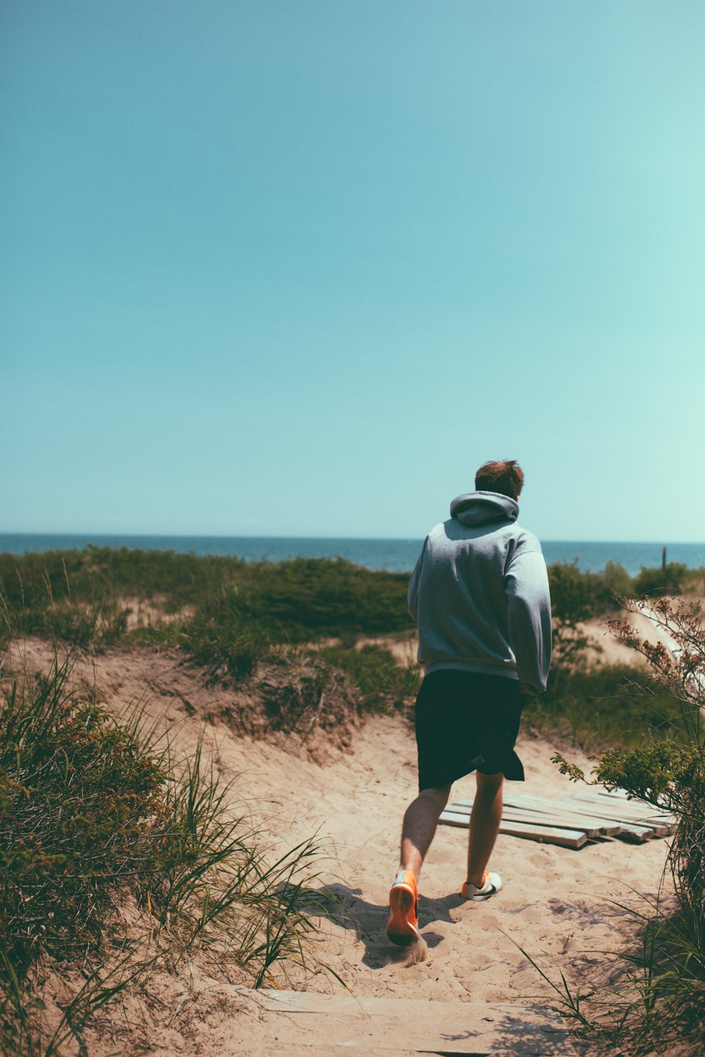 man walking on brown sand