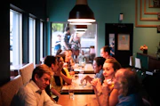 people sitting beside brown wooden table inside room