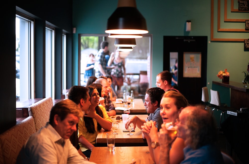 people sitting beside brown wooden table inside room