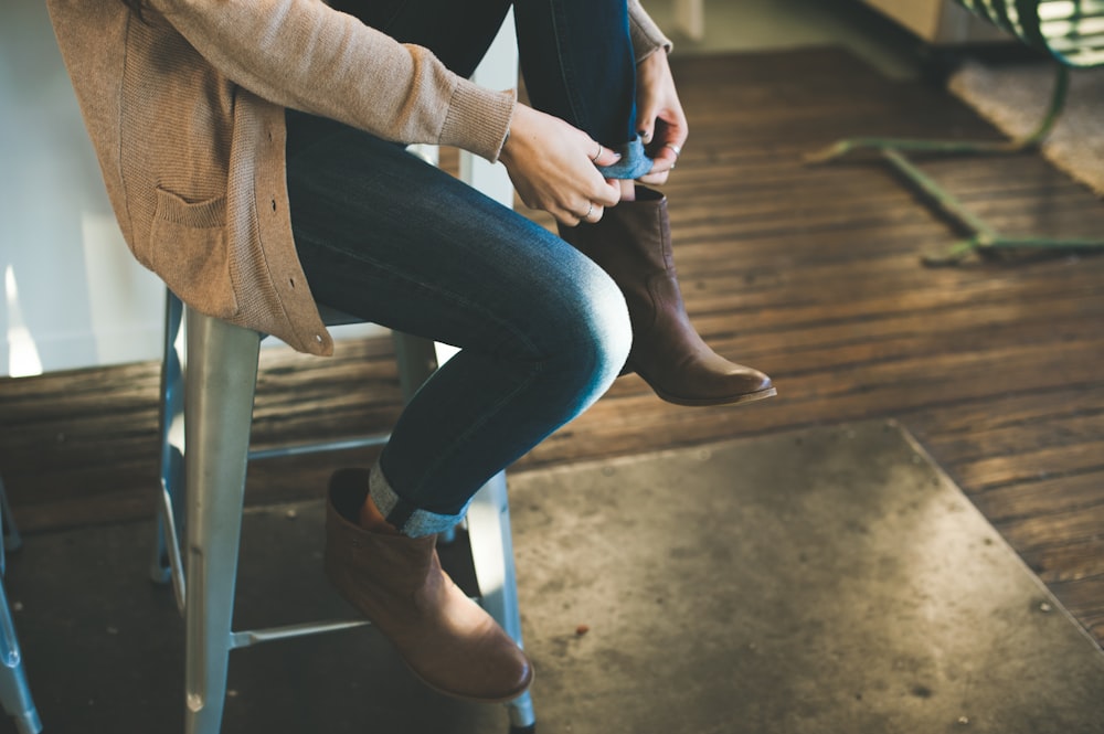 person in gray coat sitting on stool inside room