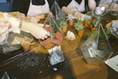 A group of smiling people gathered around a table, creating terrariums together.