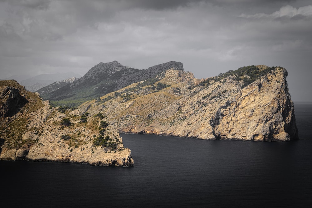 high angle photography of mountain cliff near body of water