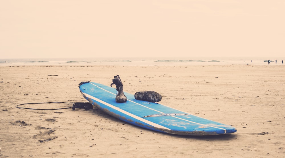 Planche de surf bleue sur sable gris