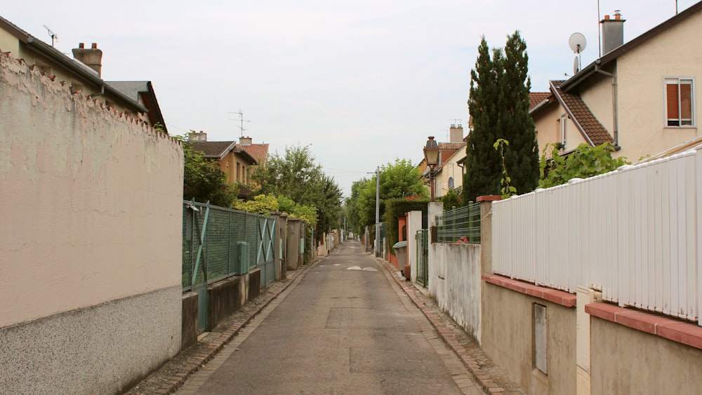 gray concrete walkway surrounded by houses during daytime