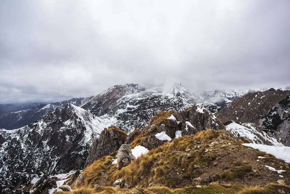 Montaña marrón y blanca bajo cielo nublado