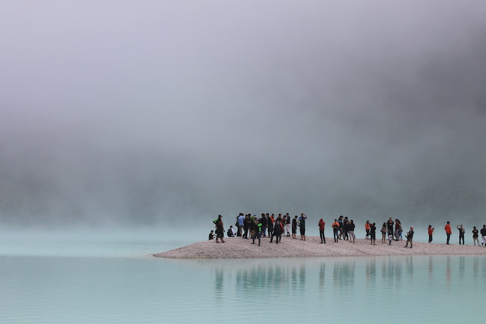 group of people standing on brown stand surrounded by body of water