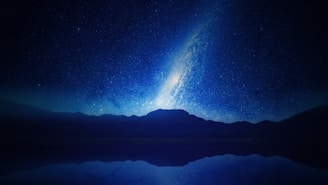 A stunning night sky filled with stars and a silhouette of mountains.