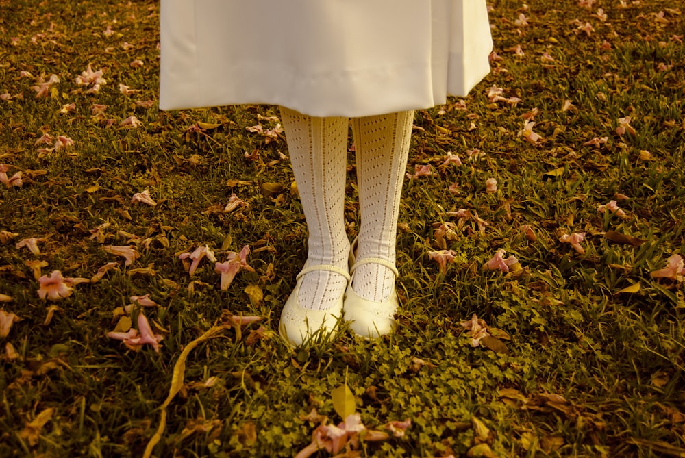 낮에 흰 드레스와 신발을 신고 풀밭에 서 있는 소녀