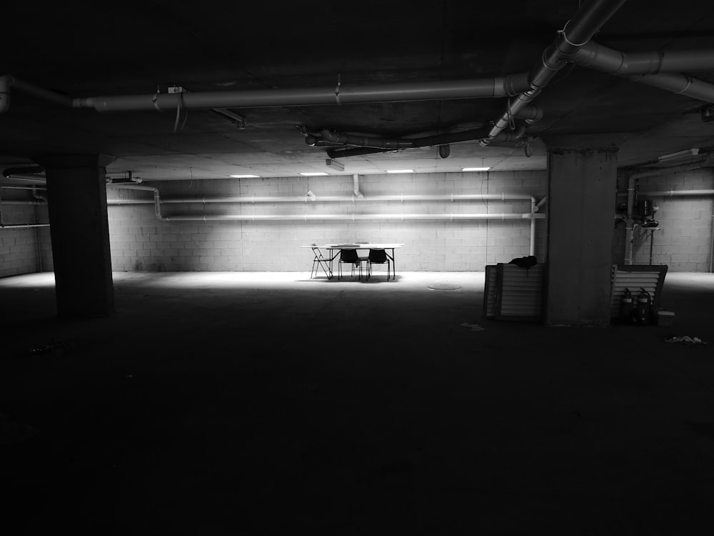 어두운 방의 벽 근처에 의자가 있는 테이블