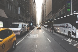 A sprinter van driving through the busy streets of Manhattan with skyscrapers towering above.