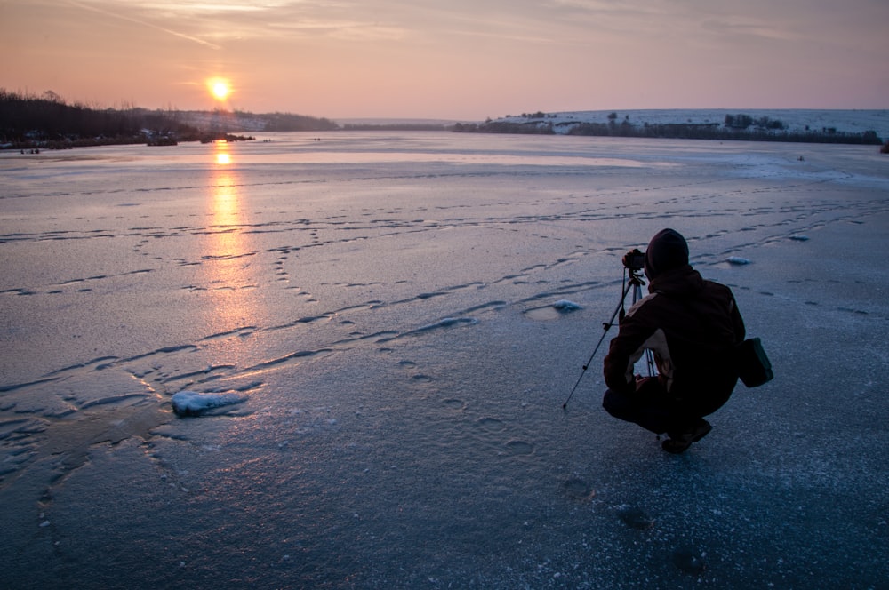 hombre tomando foto de la puesta del sol