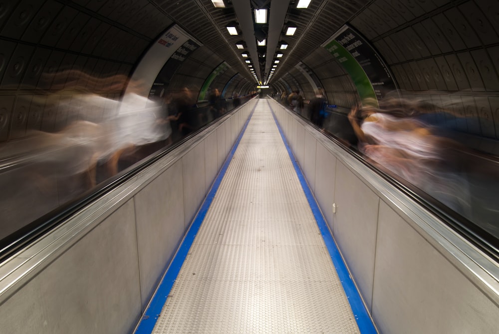 a blurry photo of people riding on an escalator