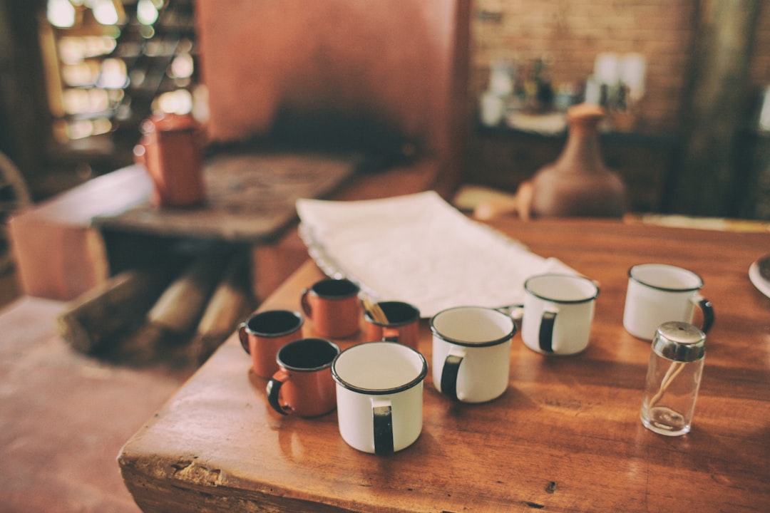  four white metal mugs on brown wooden table toothpick