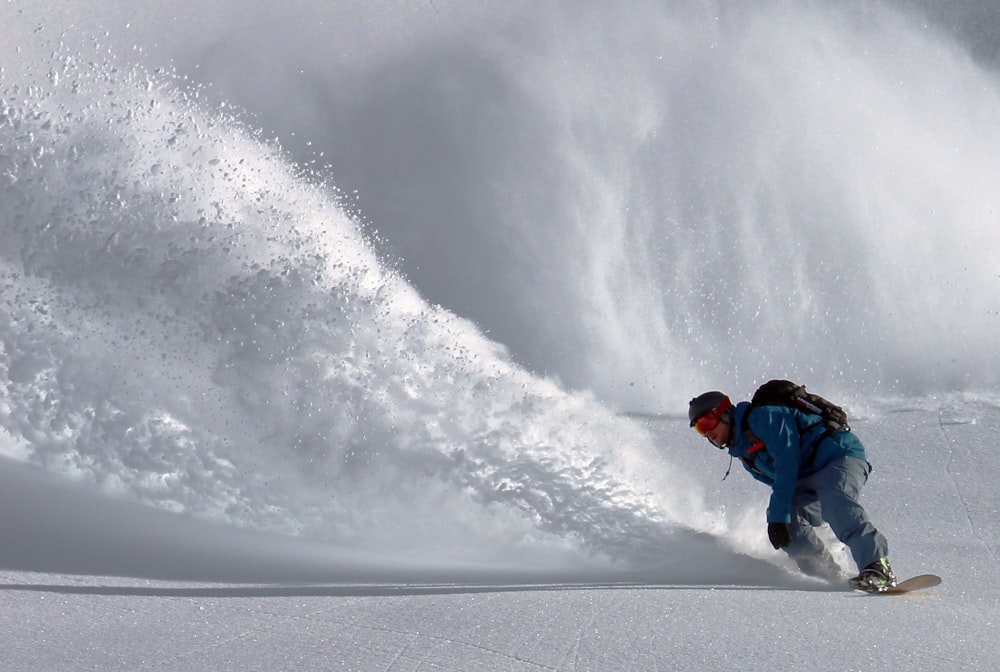 person gliding in snow during day time