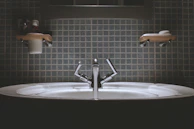 Bright bathroom scene featuring an aquaforma over-the-counter sink with bold geometric design.