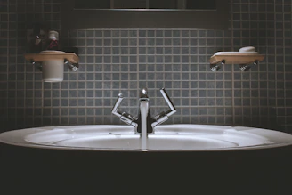 Minimalist bathroom sink with elegant blue and dark gray accents, highlighting clean lines and smooth surfaces.