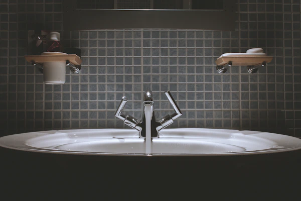 Minimalist bathroom sink with elegant blue and dark gray accents, highlighting clean lines and smooth surfaces.