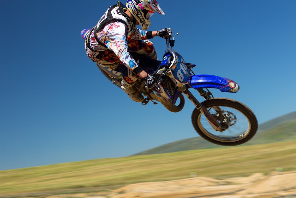 Hombre haciendo acrobacias aéreas en motocicleta durante el día