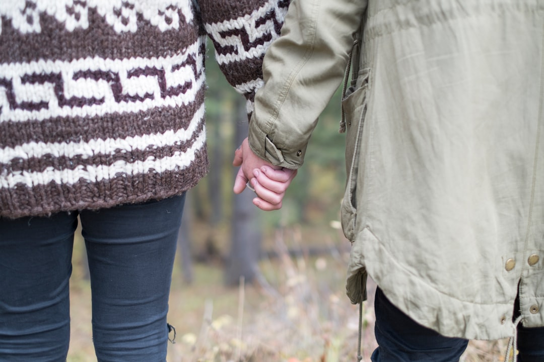 two persons holding each other's hands