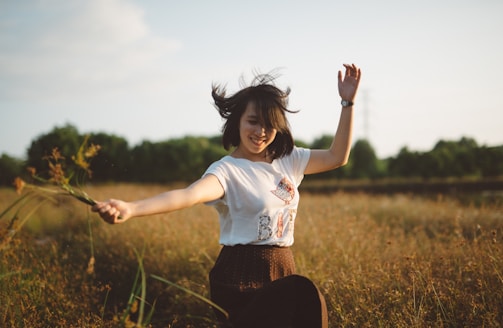 A joyful child dancing with colorful butterflies in a sunlit meadow.