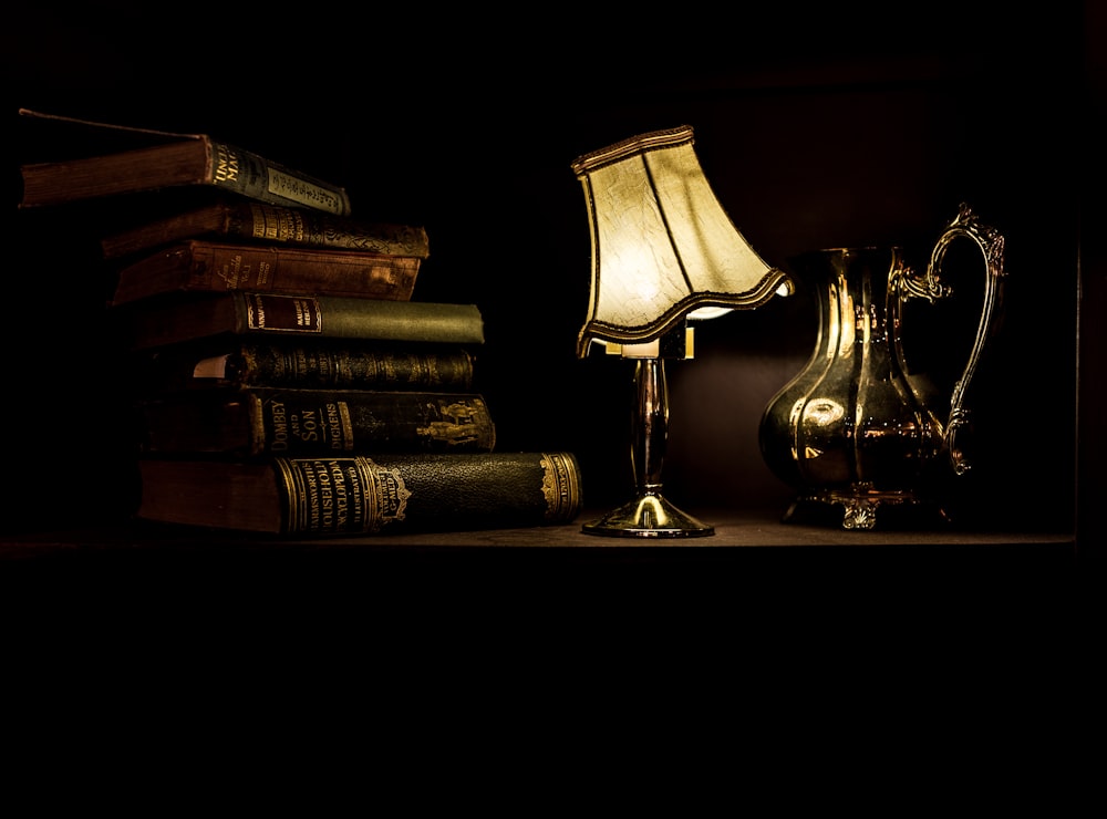acendeu a lâmpada de mesa ao lado de uma pilha de livros