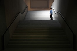 A person pausing on a staircase, reflecting the idea of taking steps one at a time.