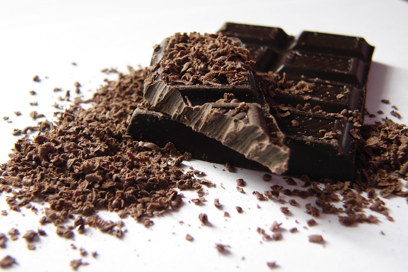 Close-up of a rich chocolate bar with intricate patterns, surrounded by coffee beans.