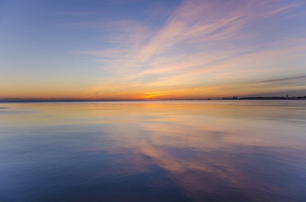 body of water under cloudy sky