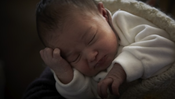 A peaceful newborn sleeping in a cozy blanket.