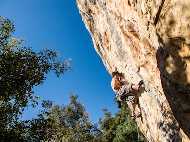 man climbing on mountain during daytime