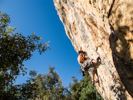 man climbing on mountain during daytime