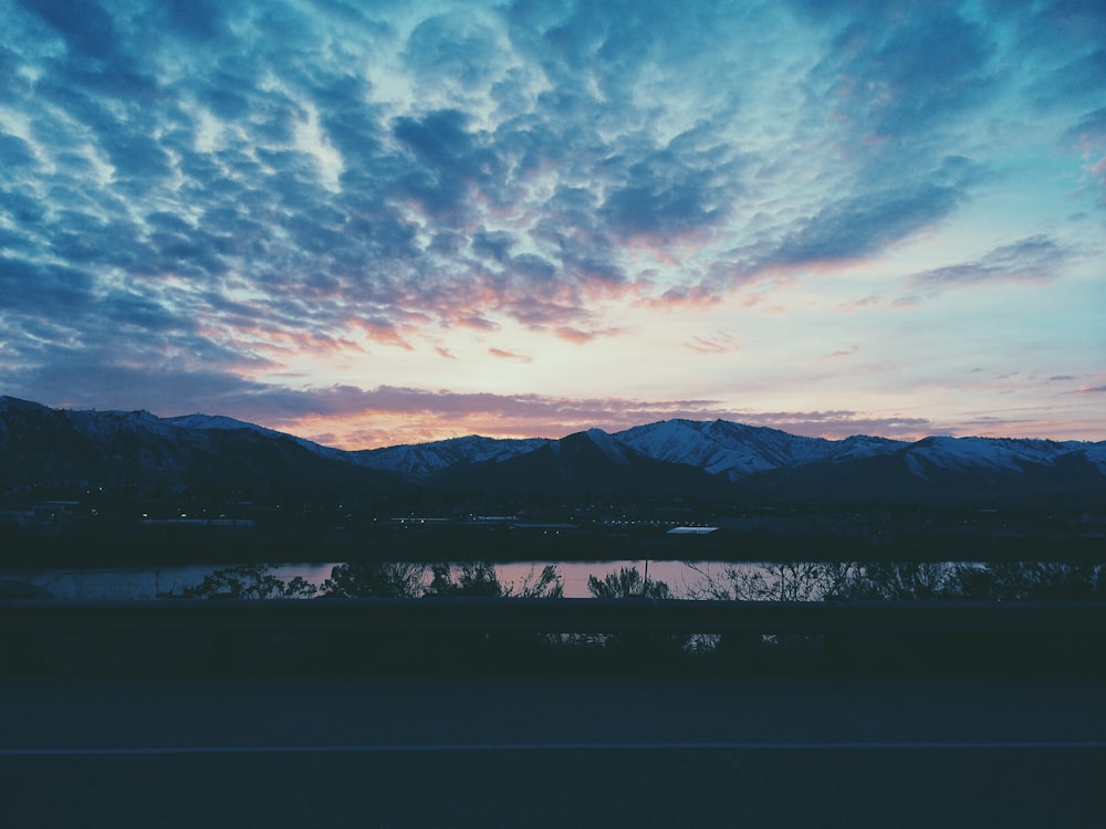 mountain near body of water under white and blue sky during nighttime photography