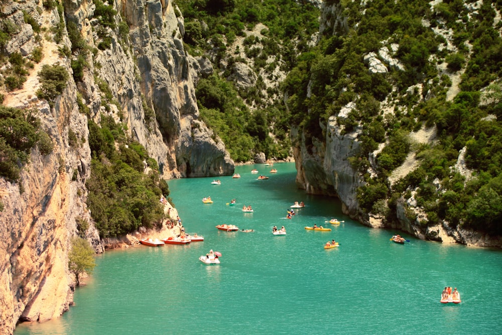 yachts sailing on water between tall mountains