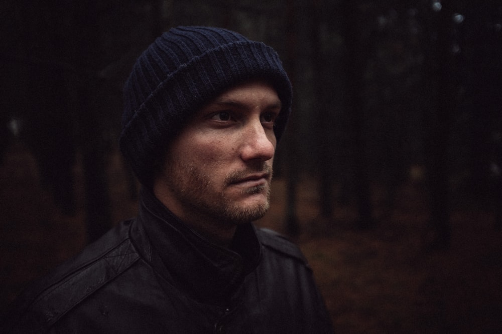 shallow focus of man standing on forest