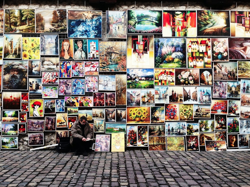 man sitting beside painting lot