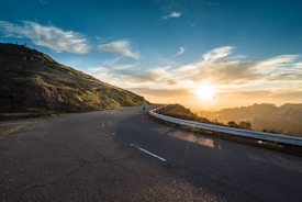 person running on road street cliff during golden hour