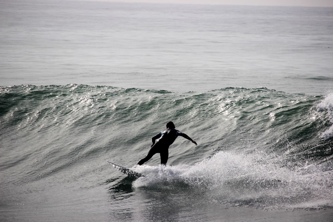 grayscale photography of surfer on body of water during daytime