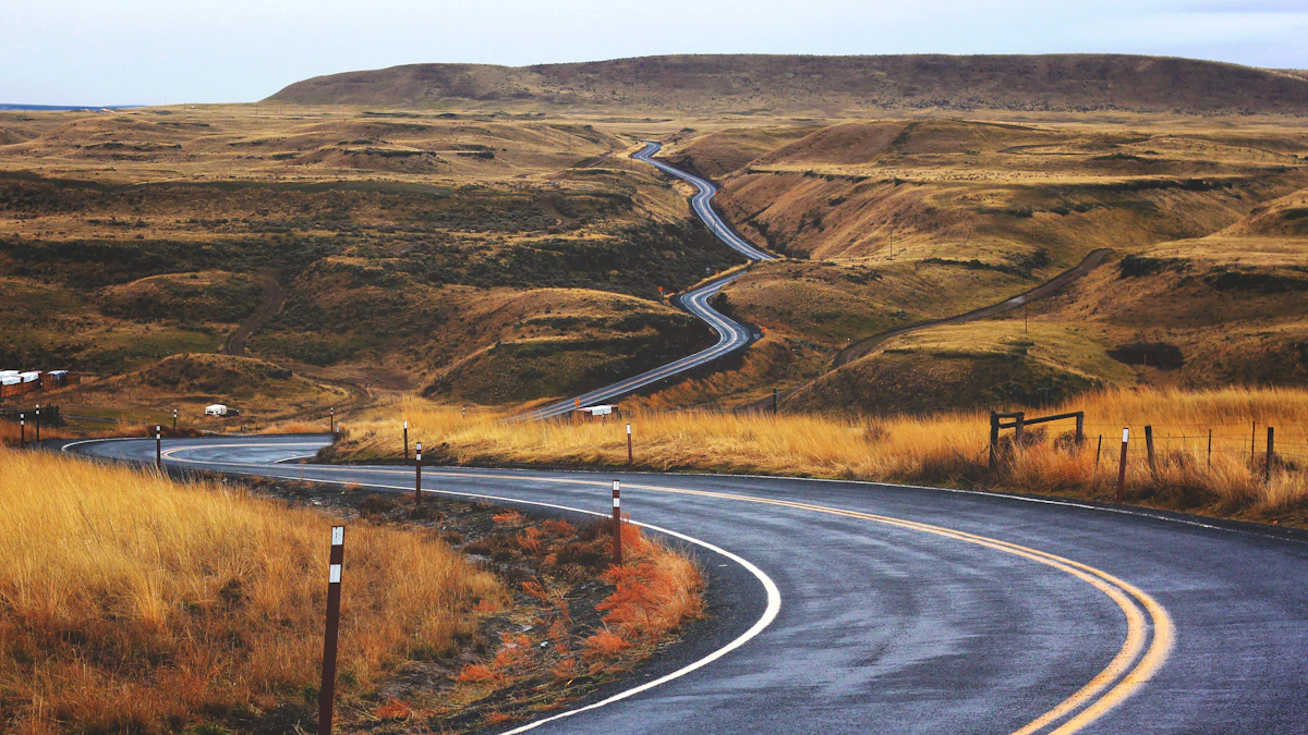 A road switchbacking steeply down a bare valley