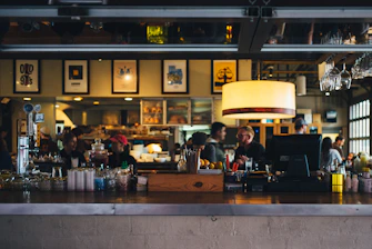 Busy full-service restaurant dining room with guests and bar area