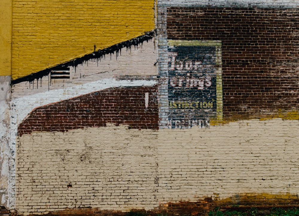 muro di mattoni in cemento marrone, giallo e beige