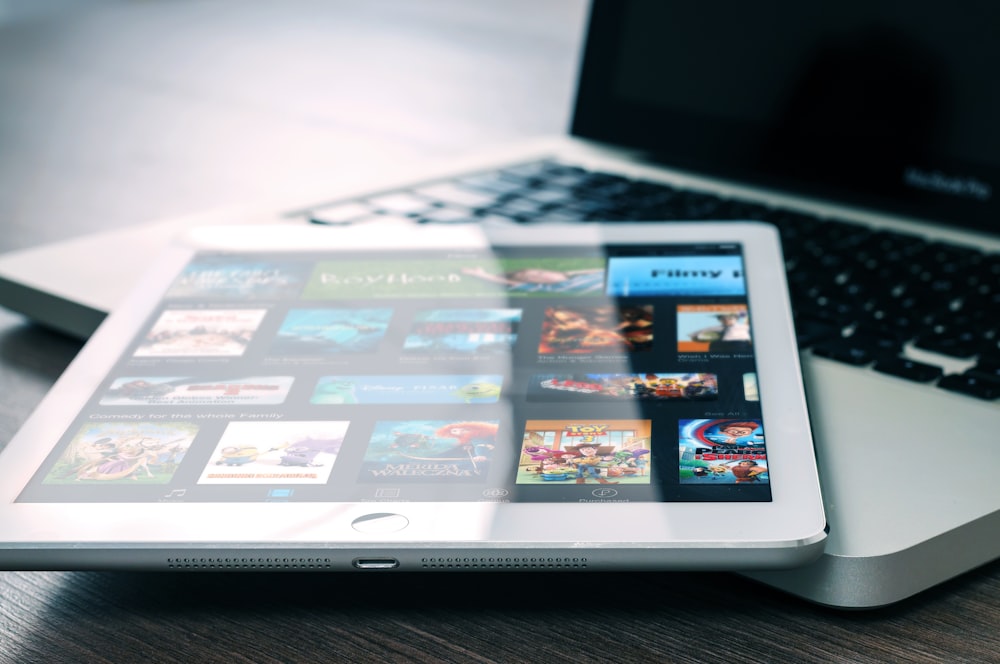 A clear electronic display of icons on a macbook pro tablet placed on a white colored laptop