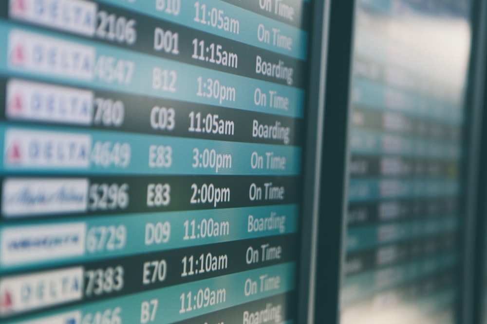 Airport departures timetable showing Delta and Alaska Airlines flights on time and boarding