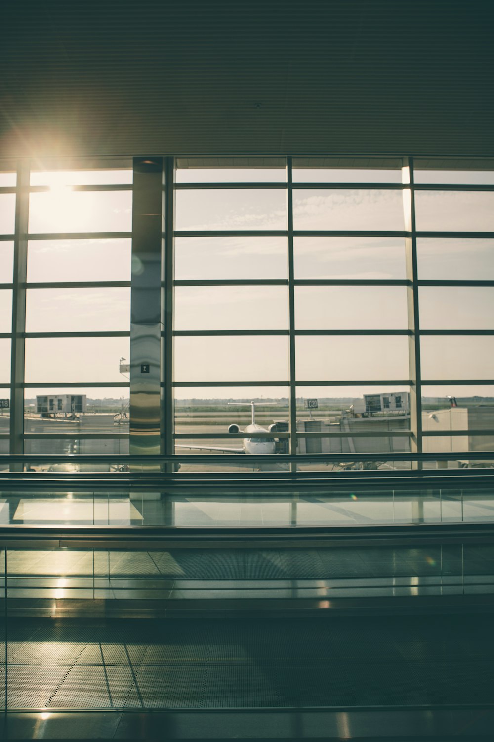 graues Metallfenster und weißes Flugzeug draußen während des Tages