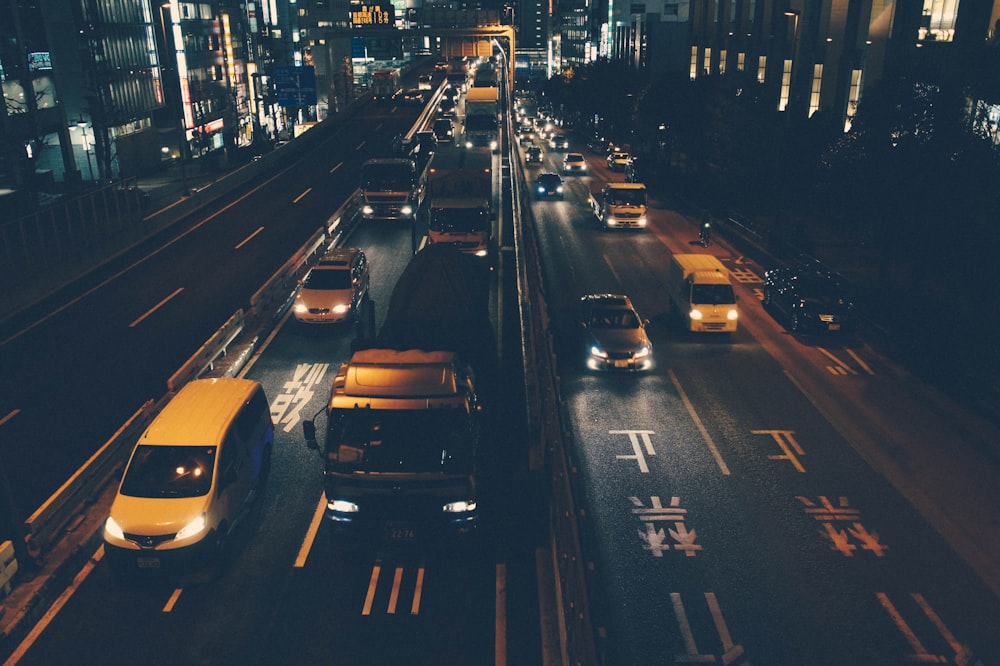 aerial photo of vehicles on road under dark sky near white buildings