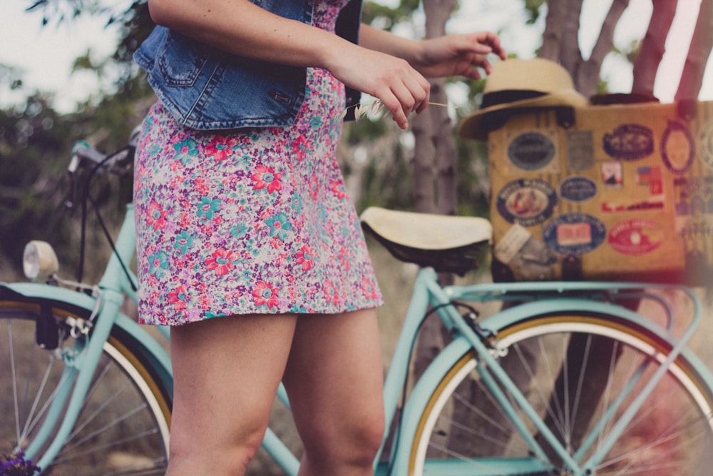 women in front of teal step-through bicycle