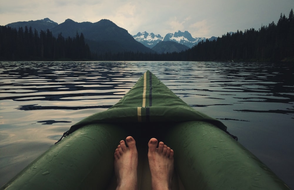 person on top of green kayak