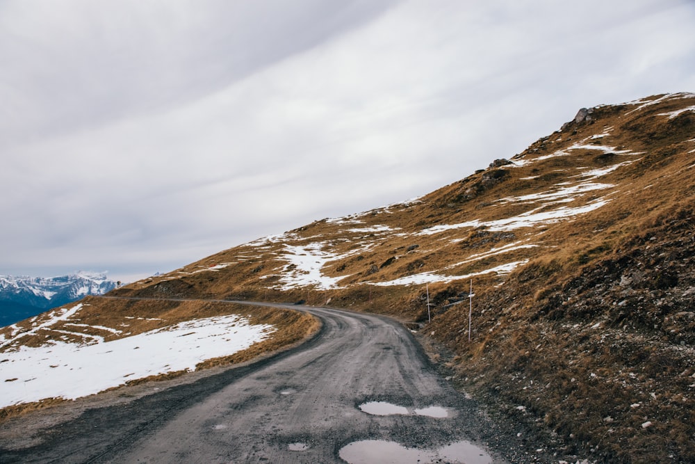 road beside mountain with snow during daytime